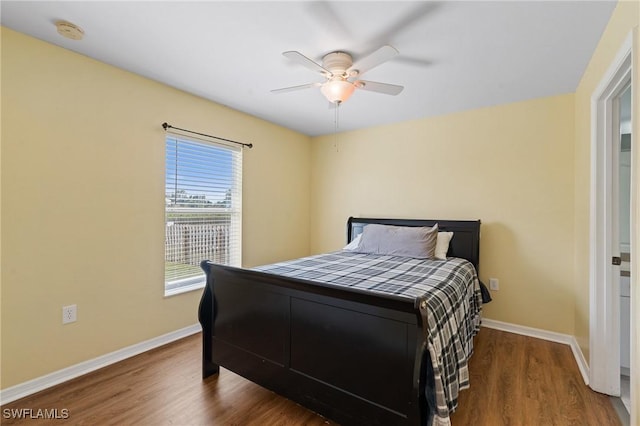 bedroom featuring a ceiling fan, baseboards, and wood finished floors