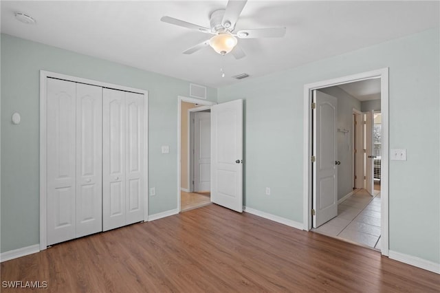 unfurnished bedroom featuring baseboards, visible vents, and wood finished floors