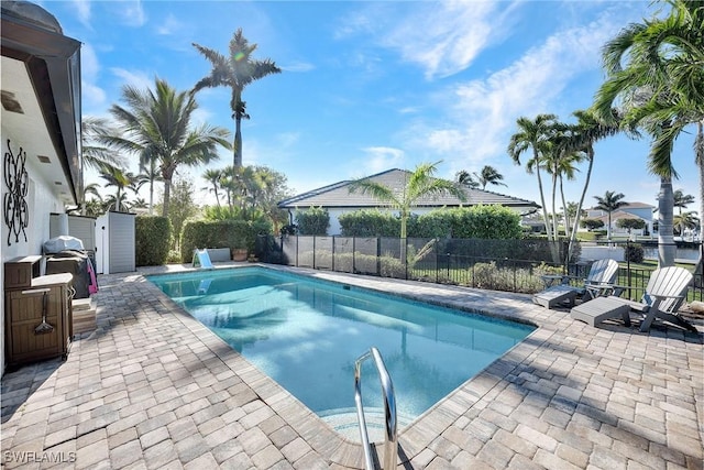 view of pool with grilling area and a patio