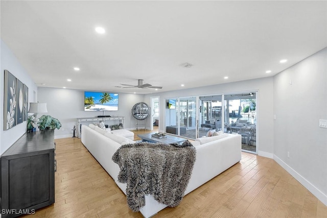 living room with ceiling fan and light hardwood / wood-style floors