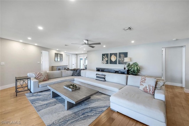 living room with ceiling fan and light wood-type flooring