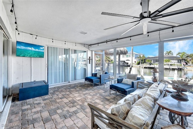 interior space with ceiling fan and a water view