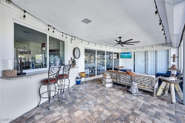 view of patio / terrace featuring ceiling fan and exterior bar