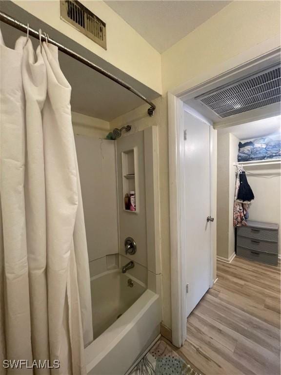 bathroom featuring hardwood / wood-style flooring and shower / bath combination with curtain