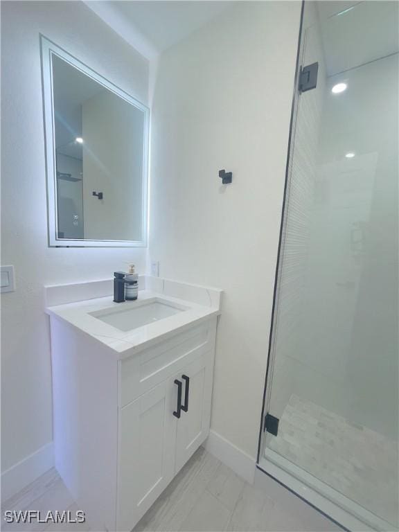 bathroom with vanity and a shower with door