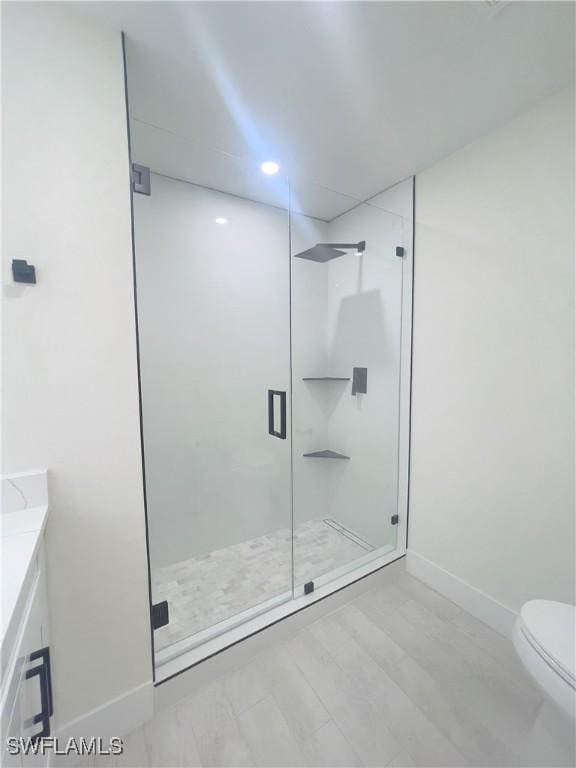 bathroom with walk in shower, vanity, and toilet