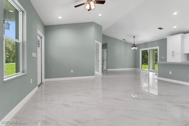 empty room with ceiling fan with notable chandelier