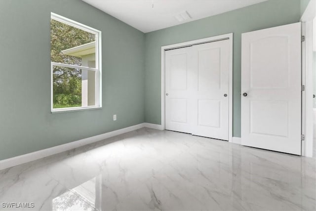 unfurnished bedroom featuring multiple windows and a closet