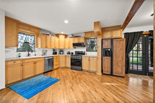 kitchen with sink, backsplash, stainless steel appliances, and light wood-type flooring