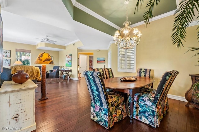 dining room featuring dark wood-type flooring, crown molding, and ceiling fan with notable chandelier