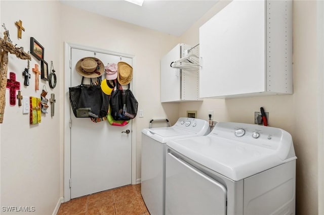 clothes washing area with light tile patterned floors, washer and clothes dryer, and cabinets