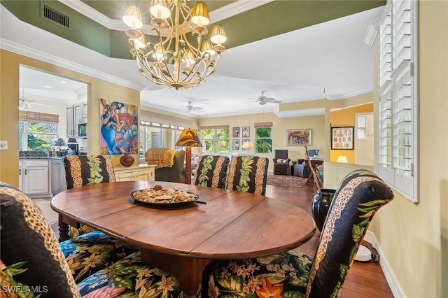 dining area featuring hardwood / wood-style floors, ceiling fan with notable chandelier, and ornamental molding