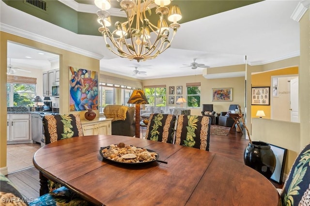 dining room with ornamental molding, plenty of natural light, and light hardwood / wood-style flooring