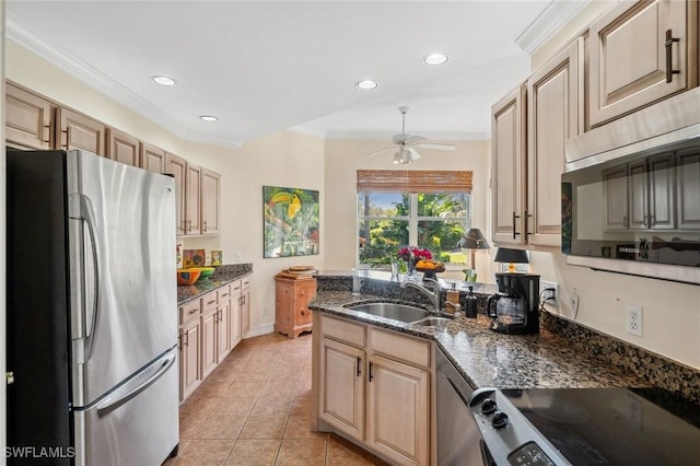 kitchen with crown molding, appliances with stainless steel finishes, sink, and dark stone countertops