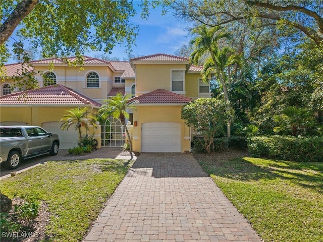 15197 Storrington Pl Unit C101, Naples, FL 34110 - mediterranean / spanish house with a tile roof, a garage, stucco siding, a front yard, and decorative driveway