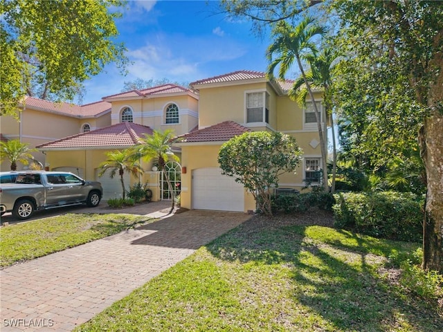 mediterranean / spanish home with a garage and a front yard