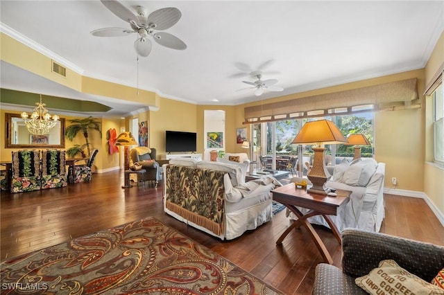 living room with dark wood-type flooring, ornamental molding, and ceiling fan with notable chandelier