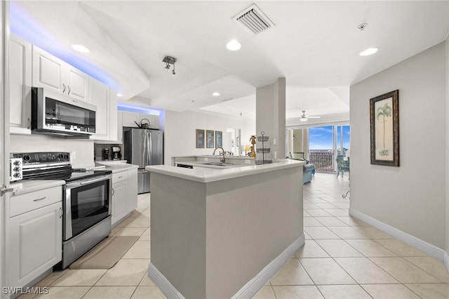 kitchen with white cabinetry, a kitchen island with sink, stainless steel appliances, and light tile patterned flooring