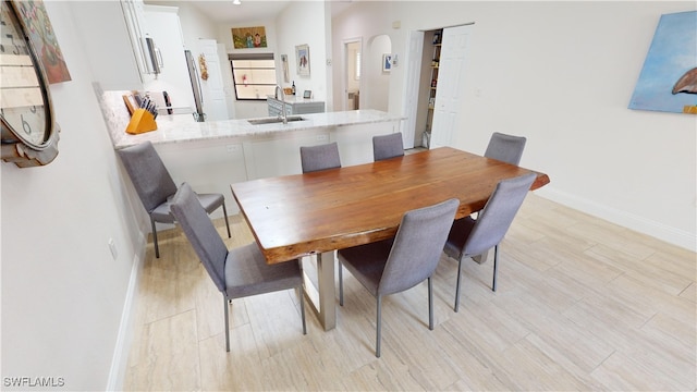 dining space with sink and light hardwood / wood-style floors