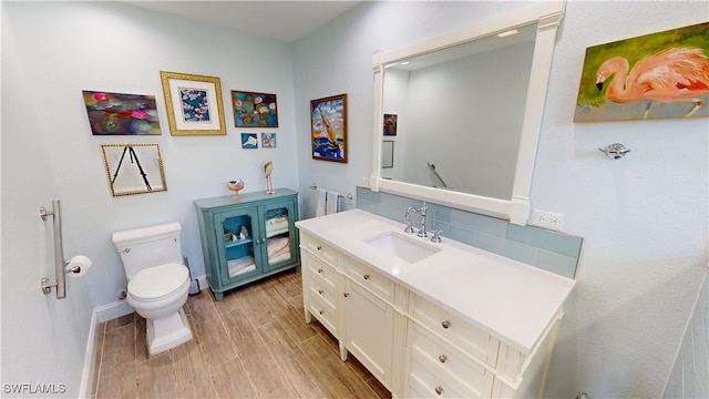 bathroom featuring vanity, hardwood / wood-style floors, and toilet