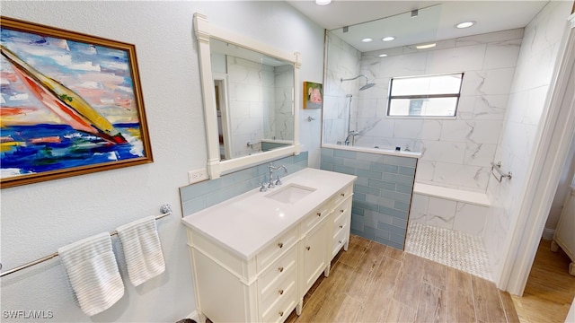 bathroom with a tile shower, vanity, and hardwood / wood-style flooring