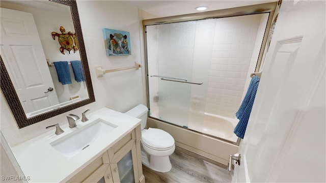 full bathroom with enclosed tub / shower combo, vanity, wood-type flooring, and toilet