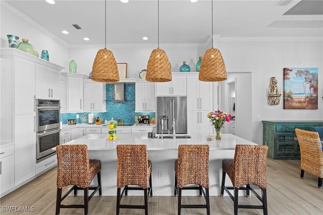 kitchen featuring stainless steel appliances, white cabinetry, a breakfast bar, and a spacious island