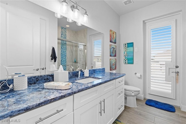 bathroom with vanity, wood-type flooring, toilet, and walk in shower