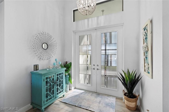 doorway featuring light hardwood / wood-style flooring, an inviting chandelier, and french doors