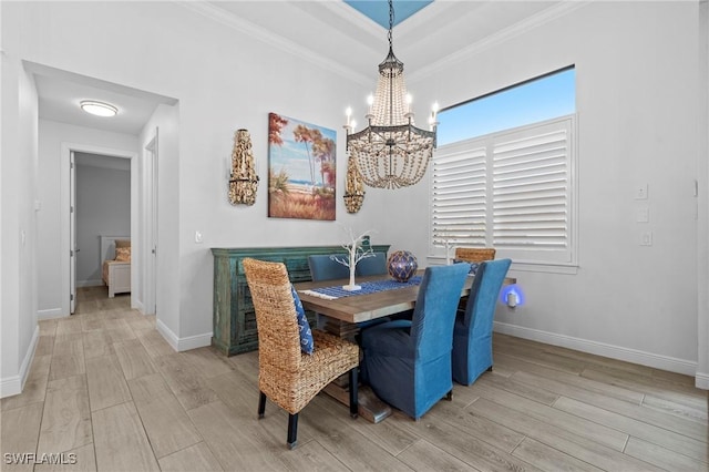 dining area featuring crown molding, light hardwood / wood-style flooring, and a chandelier