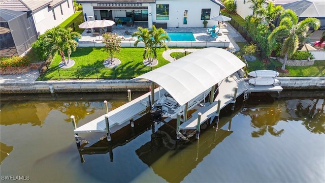 view of dock featuring a patio, a water view, and a yard