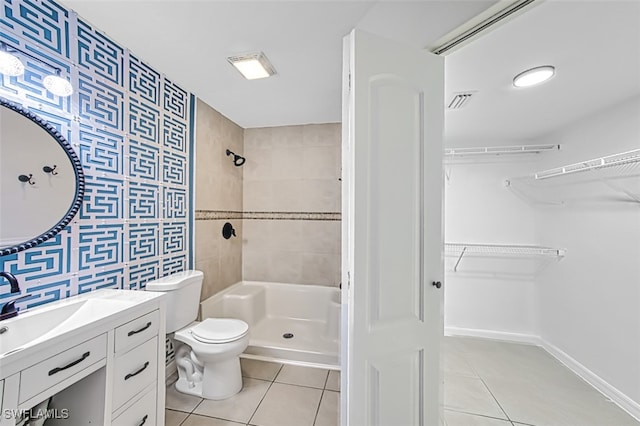 bathroom with vanity, tiled shower, tile patterned floors, and toilet