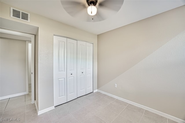 unfurnished bedroom featuring light tile patterned floors, a closet, and ceiling fan