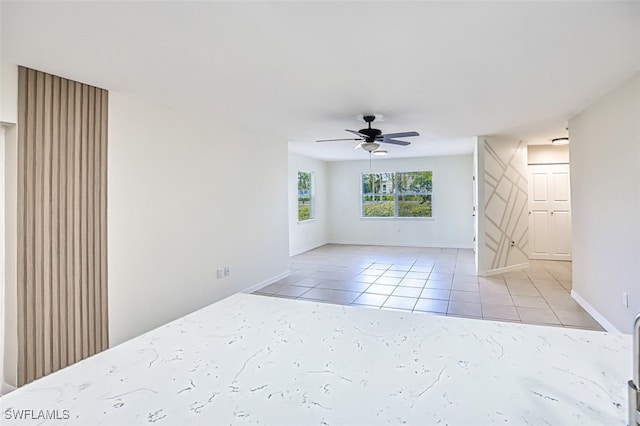 unfurnished room with ceiling fan and light tile patterned flooring