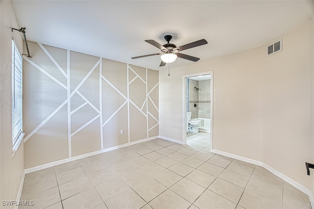 tiled spare room with ceiling fan