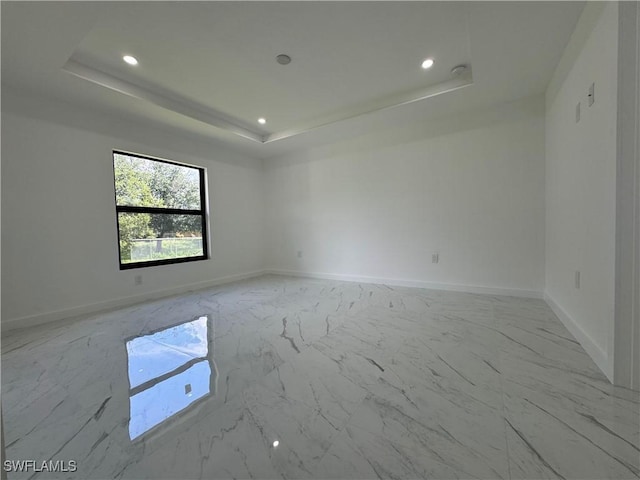 spare room with a tray ceiling