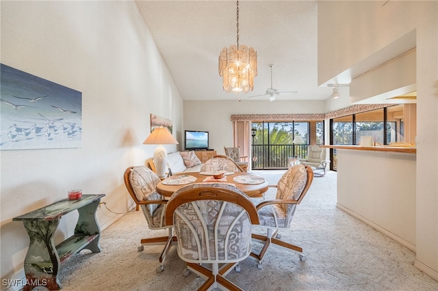 dining area featuring vaulted ceiling, light colored carpet, and ceiling fan with notable chandelier