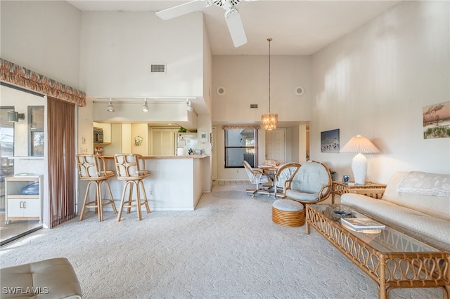 carpeted living room featuring ceiling fan, rail lighting, and high vaulted ceiling