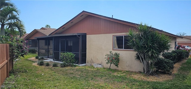 rear view of property featuring a sunroom and a yard