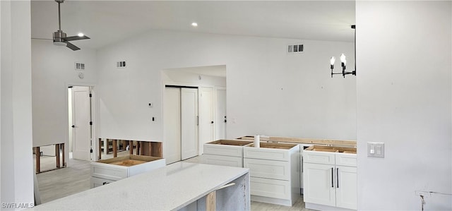 kitchen with white cabinetry, ceiling fan, decorative light fixtures, and high vaulted ceiling