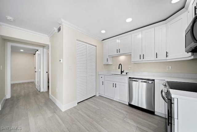 kitchen with white cabinetry, sink, crown molding, and stainless steel appliances