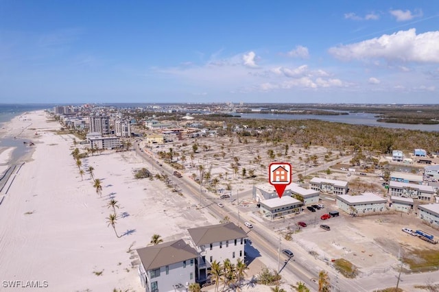 birds eye view of property with a water view and a beach view