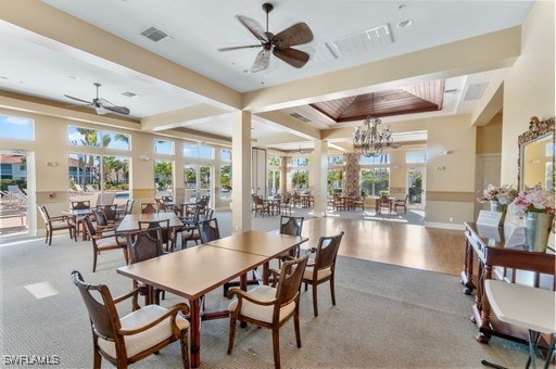 dining room with baseboards, visible vents, a raised ceiling, and ceiling fan with notable chandelier