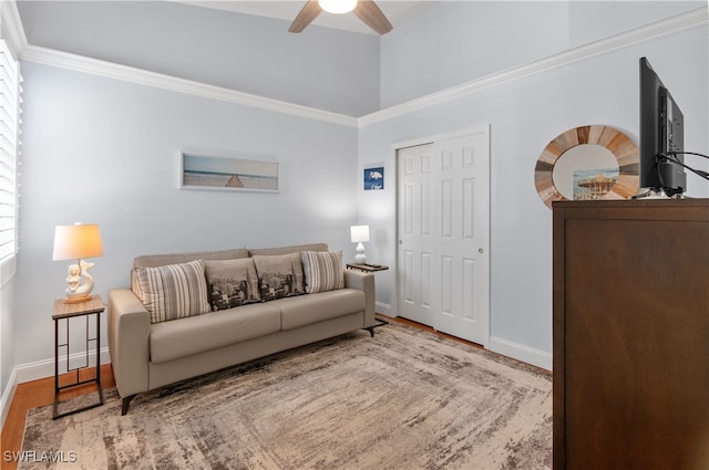 living room featuring a ceiling fan, baseboards, and wood finished floors