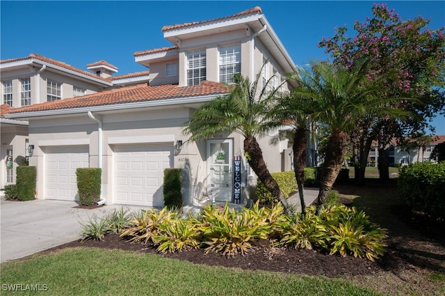 view of front of house featuring concrete driveway, an attached garage, a tile roof, and stucco siding