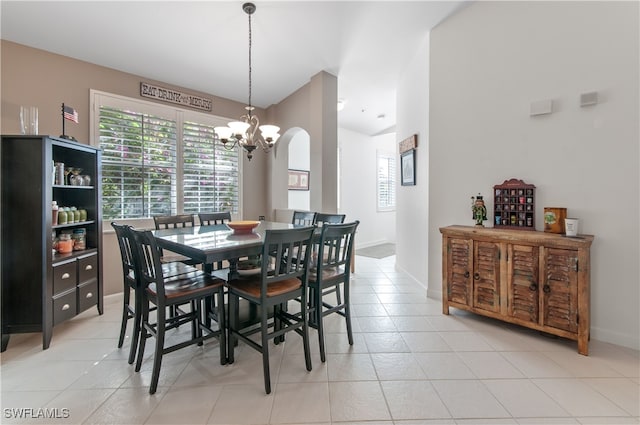 dining room with a healthy amount of sunlight, light tile patterned floors, and a notable chandelier