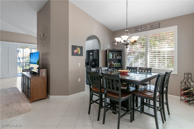 dining space with lofted ceiling, arched walkways, baseboards, and an inviting chandelier