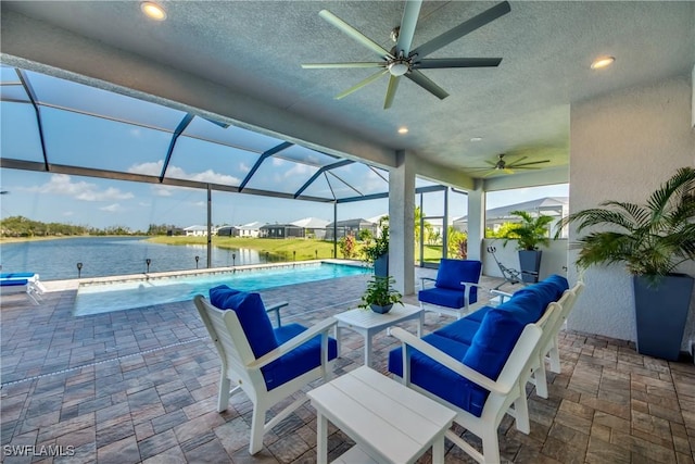 view of patio with outdoor lounge area, pool water feature, ceiling fan, glass enclosure, and a water view