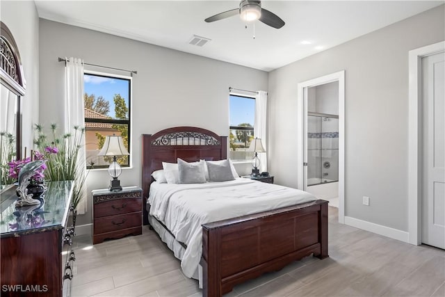 bedroom with multiple windows, visible vents, baseboards, and connected bathroom