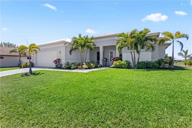 view of front facade with stucco siding, a front yard, an attached garage, and driveway